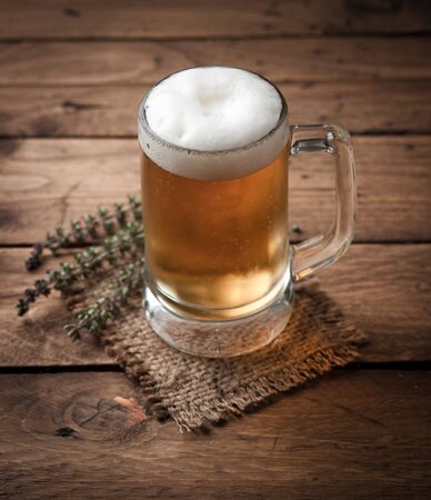 glass of beer on wooden tableの写真素材