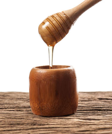 Fresh natural honey in a jar with honey spoon on a woodenの写真素材