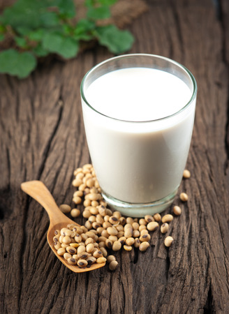 Soy milk with beans on woodの写真素材