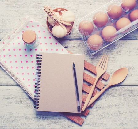 Book with wooden spoons on wood, vintage tonedの写真素材