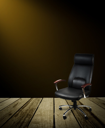 Black leather office chair on wood floor,dark backgroundの写真素材