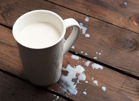 Glass of milk on rustic wooden backgroundの写真素材