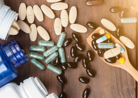 Medical pill on wooden table.