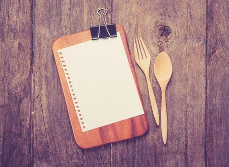 Blank clip menu sheet of paper and spoon on rustic wooden,vintage color toned imageの写真素材