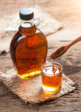 maple syrup in glass bottle on wooden tableの写真素材