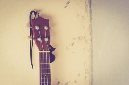 Still life with ukulele Old on the wall,vintage color toned imageの写真素材