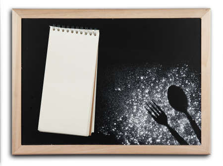 Imprint fork and spoon made of flour with notepads recipes on blackboardの写真素材