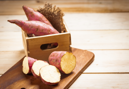 Raw sweet potatoes on a wooden background . Selective focusの写真素材