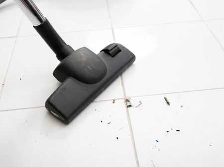 Vacuum cleaning dirt on a tiled floorの写真素材