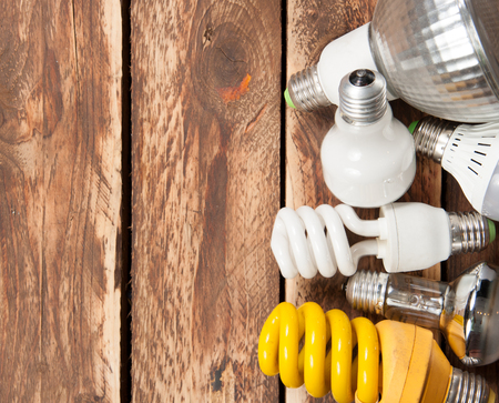 Different lightbulbs on wooden background,top view