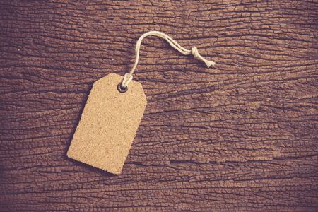 Blank natural cork label tag on wood background
,vintage color toned imageの写真素材