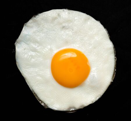 Fried egg isolated on black background
