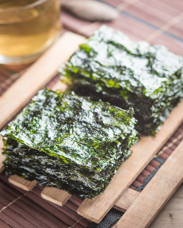 Nori sheets with tea in a glass on woodの写真素材