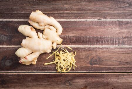 Ginger root sliced on wooden background,top view