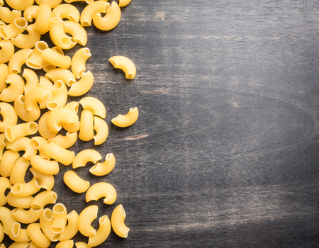 Raw macaroni on dark wooden background,Top viewの写真素材