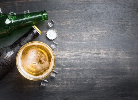 Beer glass with bottle cap and bottle on rustic wood background,space for text,top viewの写真素材