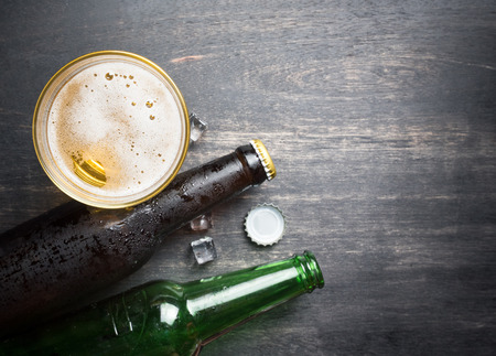 Beer glass with bottle cap and bottle on rustic wood background,space for text,top viewの写真素材
