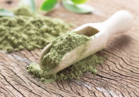 powder green tea with green tea leaf and scoop on wood backgroundの写真素材