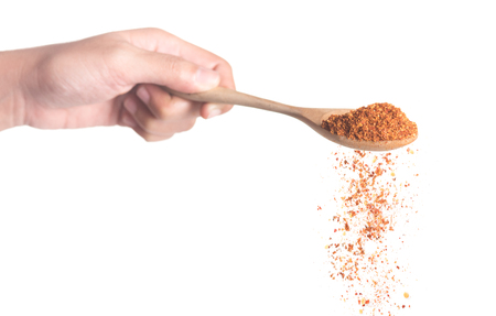 Cayenne pepper in wooden spoon isolated on white background,Flying Cayenne pepperの写真素材