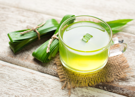 Glass of pandan juice and pandan leaves on wood backgroundの写真素材