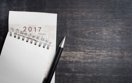 Daily note book with New Year 2017 office organizer calendar on wood tableの写真素材
