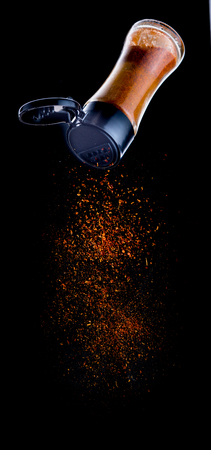 Cayenne pepper pour from Bottle on black,Flying Cayenne pepperの写真素材