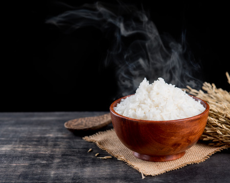 Cooked rice with smoke in wooden bowl,dark backgroundの写真素材