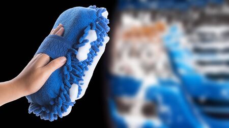 Hand hold car washing mitt glove sponge with foam on blurred car washing