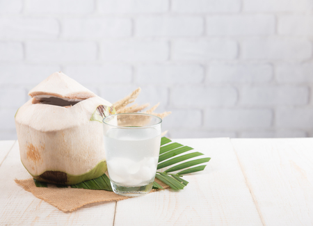 Coconut juice,Drink coconut water on table against white brick wallの写真素材