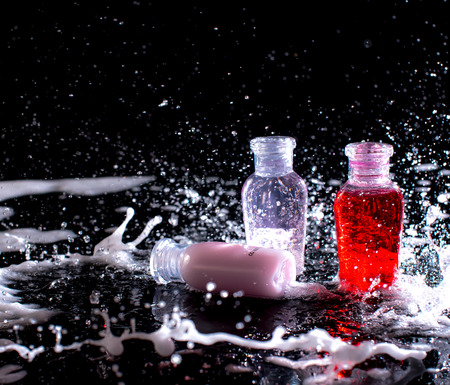 shower gel and shampoo with splashes of water on the dark backgroundの写真素材