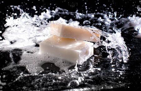 Soap bar with splashes of water on the dark backgroundの写真素材