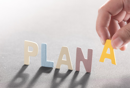 PLAN A word made from colored wooden letters with human's finger