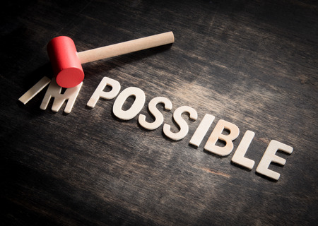 Hammer destroying the wooden letters in from the word impossible so it says possible.