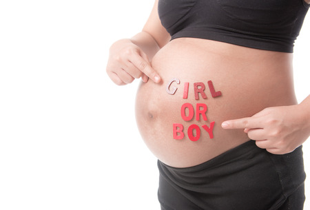 Belly of a pregnant woman with the word " BOY OR GIRL " isolated on white backgroundの写真素材