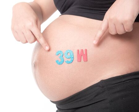 Belly of a pregnant woman with the word " 39 week " isolated on white backgroundの写真素材