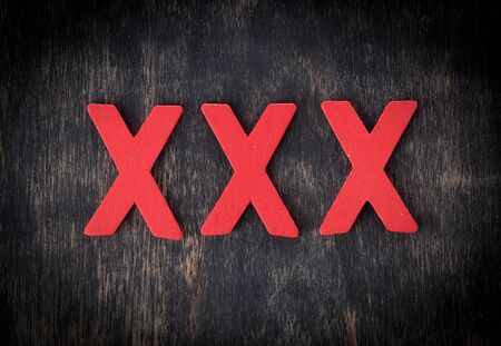 XXX word made from red wooden letters on wood,top viewの写真素材