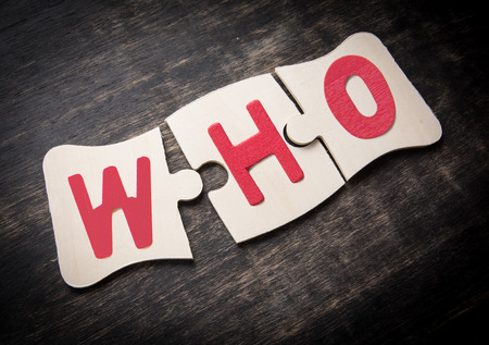 Three pieces of a puzzle with the word "WHO" on a rustic wooden,Jigsaw business idea conceptの写真素材