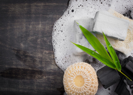 Black coal bar of soap with wood charcoal on dark wood,top viewの写真素材