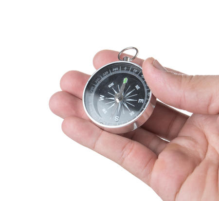 Hand holding black compass isolated on white backgroundの写真素材