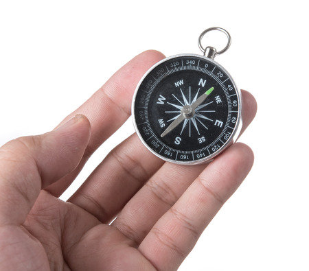Hand holding black compass isolated on white backgroundの写真素材