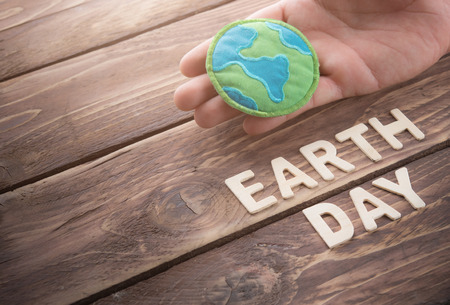 Earth day word with fabric earth globe on wood background, earth day concept