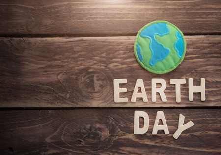 Earth day word with fabric earth globe on wood background, earth day concept