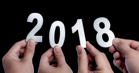 New year 2018,Hands holding Metal words of 2018 over dark background