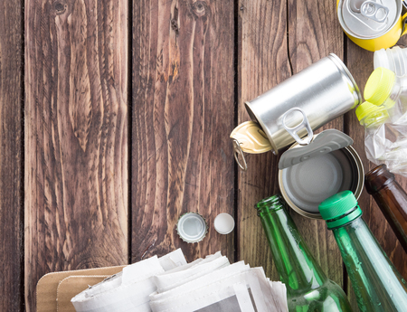 Recyclable garbage consisting of glass, plastic bottle, metal and paper on wood background,top viewの写真素材