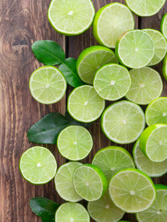 Sliced of  limes on wood background,top viewの写真素材