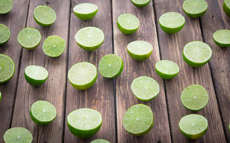 Sliced of  limes on wood background,top viewの写真素材