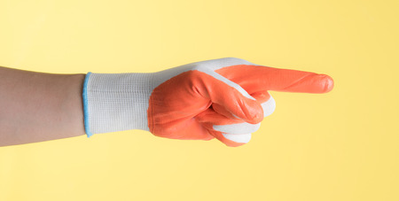 Hand with work glove against yellow backgroundの写真素材