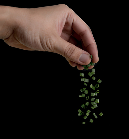 hand sprinkling onion on black background,Chopped green onionsの写真素材