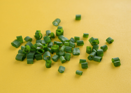 Chopped green onion on yellow backgroundの写真素材