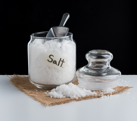 Glass jar with sea salt on tableの写真素材